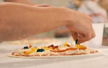 Garnish your own pizza during our pizza and gelato class near Florence